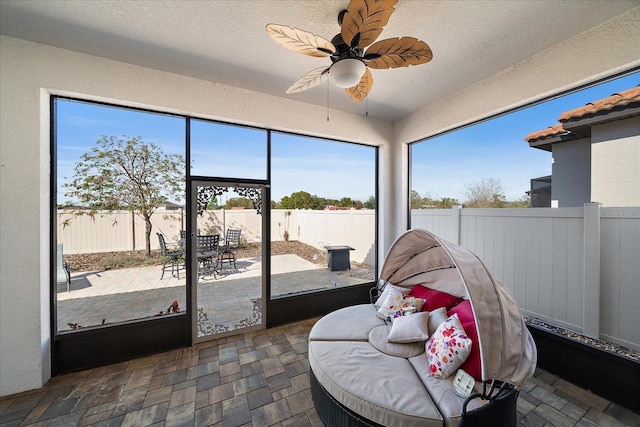 sunroom featuring a ceiling fan