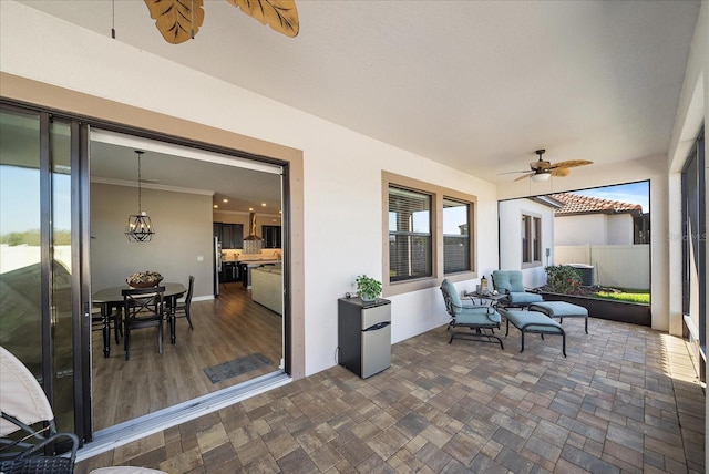 sunroom / solarium with ceiling fan with notable chandelier