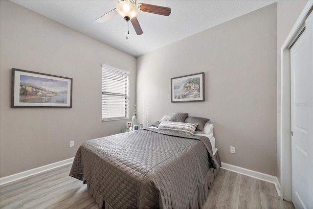 bedroom featuring ceiling fan, light wood finished floors, and baseboards