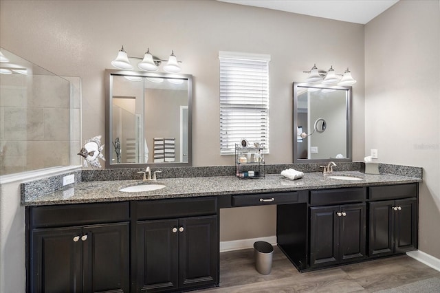 full bathroom featuring double vanity, a sink, and baseboards