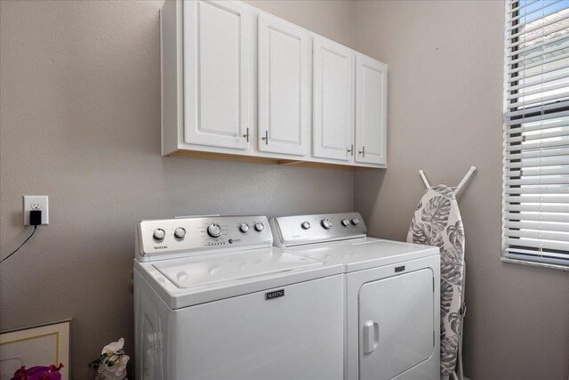 washroom with independent washer and dryer and cabinet space