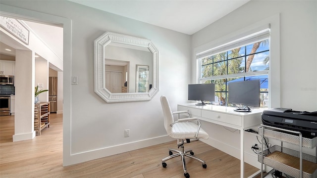 office with light wood-type flooring and baseboards