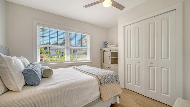 bedroom with a closet, light wood-style flooring, and ceiling fan