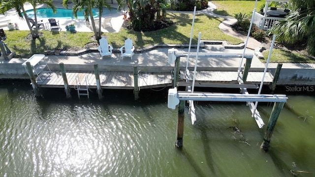 dock area featuring boat lift, a yard, and a water view