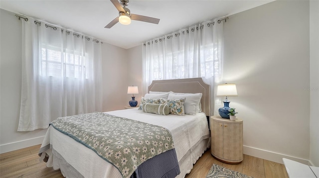 bedroom featuring a ceiling fan, light wood-type flooring, and baseboards