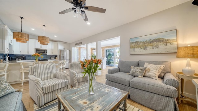 living room featuring recessed lighting, light wood finished floors, vaulted ceiling, and a ceiling fan
