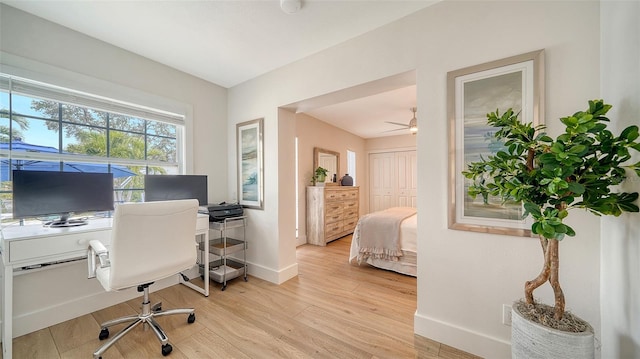 office space featuring ceiling fan, light wood finished floors, and baseboards