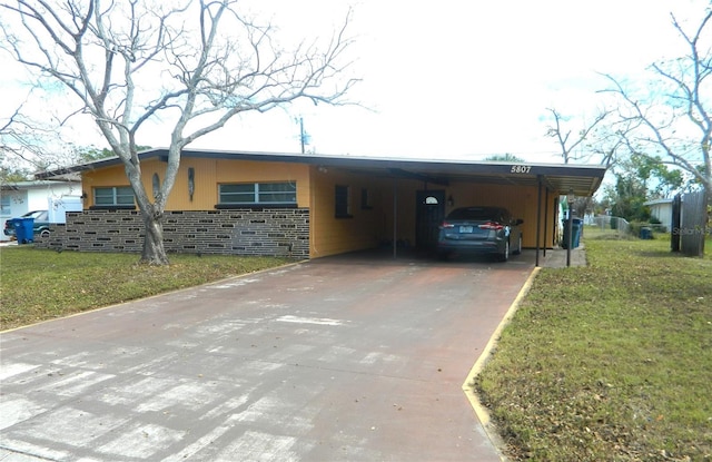 view of front facade with driveway, a front lawn, an attached carport, and stucco siding