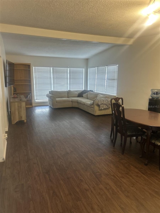 unfurnished dining area with dark wood-style floors and a textured ceiling