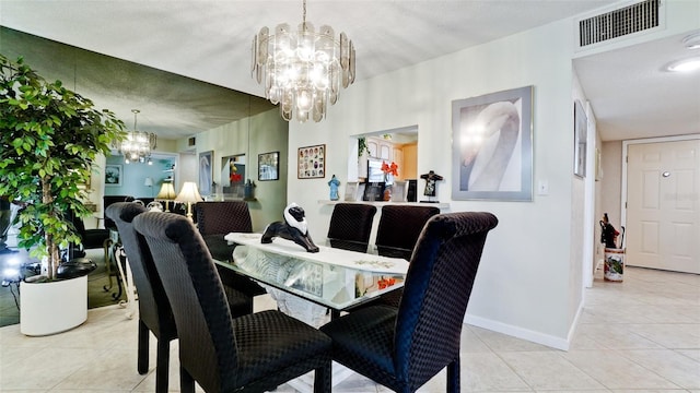 dining area featuring a chandelier, tile patterned flooring, visible vents, and baseboards