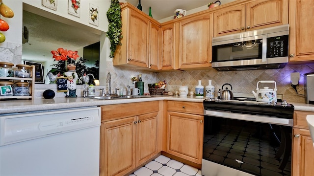 kitchen with electric stove, light countertops, stainless steel microwave, white dishwasher, and a sink