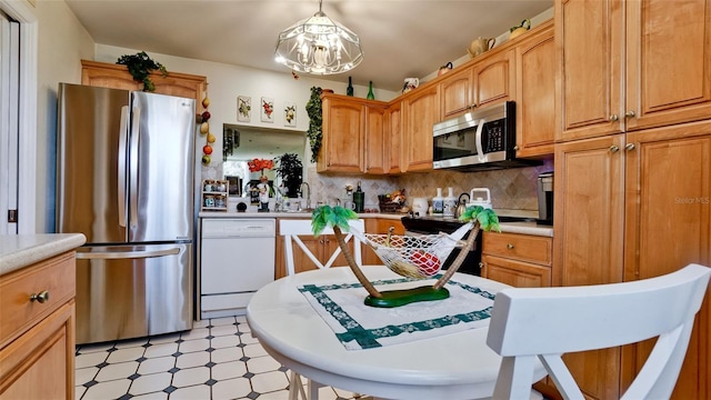 kitchen featuring light floors, appliances with stainless steel finishes, backsplash, and light countertops