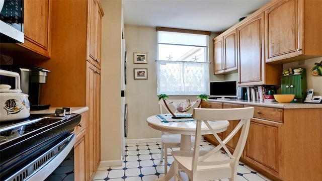 kitchen featuring light floors, baseboards, and light countertops