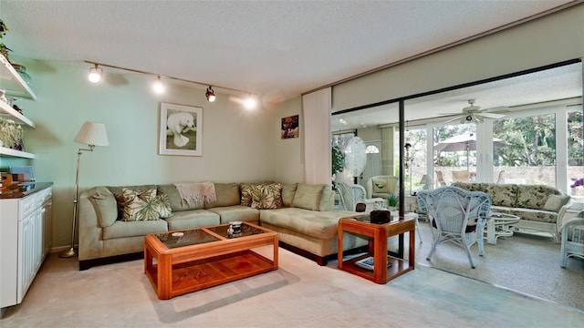 living room with light carpet, track lighting, and a textured ceiling