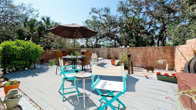 wooden terrace featuring outdoor dining area and fence