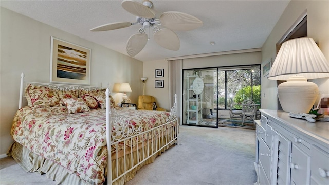 carpeted bedroom featuring access to exterior, a textured ceiling, and a ceiling fan