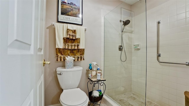 full bathroom with a tile shower and toilet