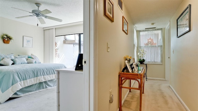 bedroom featuring light carpet, a textured ceiling, visible vents, and baseboards