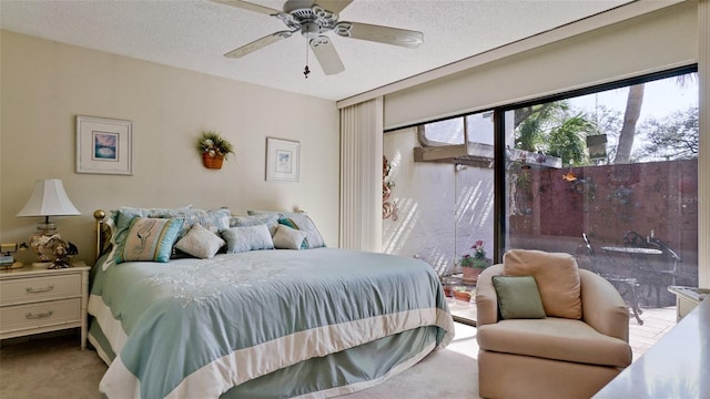 bedroom featuring access to outside, a ceiling fan, a textured ceiling, and carpet flooring