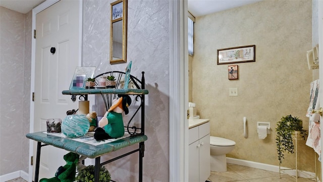 bathroom with toilet, tile patterned flooring, baseboards, and vanity