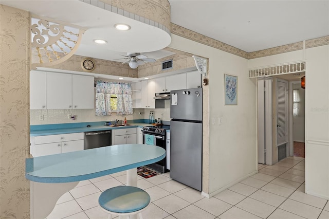 kitchen with under cabinet range hood, visible vents, stainless steel appliances, and wallpapered walls