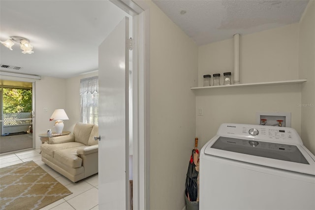 clothes washing area featuring light tile patterned floors, a textured ceiling, laundry area, visible vents, and washer / clothes dryer