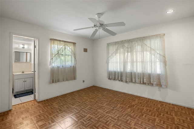 unfurnished bedroom with ensuite bath, a sink, and a ceiling fan