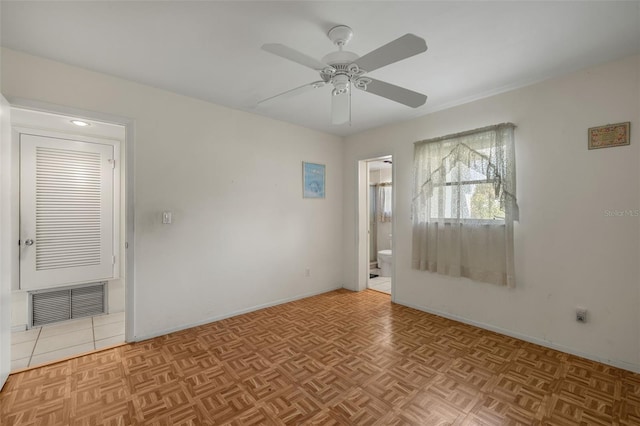 empty room with ceiling fan, visible vents, and baseboards