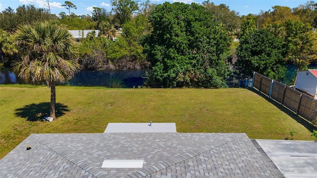 view of yard with a water view, a patio area, and fence