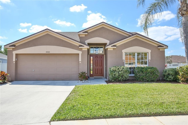 single story home with a garage, a front yard, concrete driveway, and stucco siding