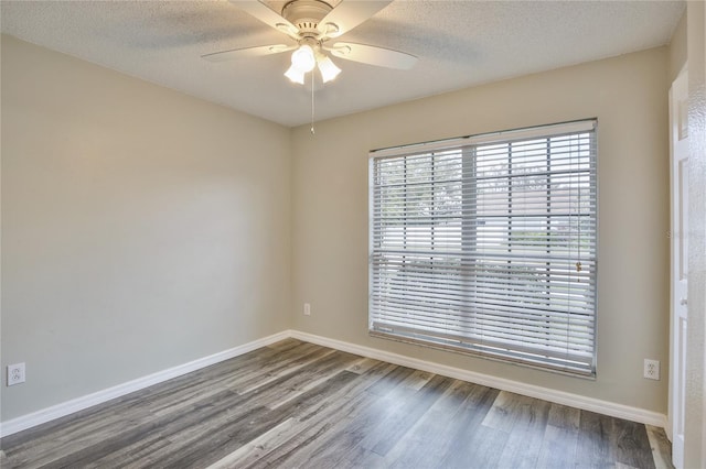 unfurnished room featuring a textured ceiling, wood finished floors, a ceiling fan, and baseboards