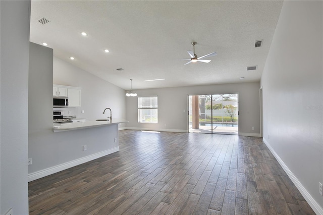 unfurnished living room featuring dark wood finished floors, a sink, and visible vents