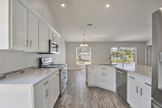 kitchen with light wood finished floors, stainless steel appliances, a sink, and light countertops