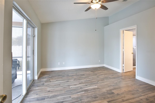 spare room with lofted ceiling, ceiling fan, baseboards, and wood finished floors