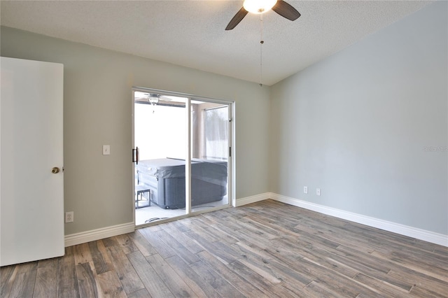 spare room featuring a ceiling fan, a textured ceiling, baseboards, and wood finished floors