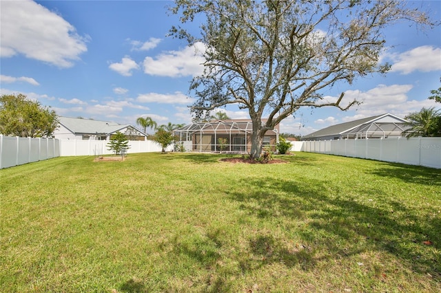 view of yard featuring glass enclosure and a fenced backyard