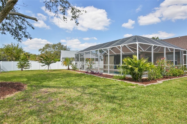 back of house with a fenced in pool, glass enclosure, a fenced backyard, and a lawn