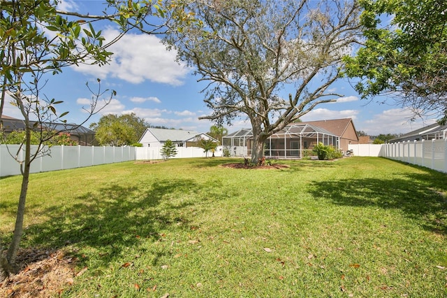 view of yard with a lanai and a fenced backyard