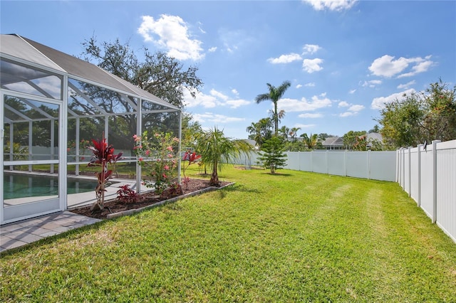 view of yard with glass enclosure, a fenced backyard, and a fenced in pool