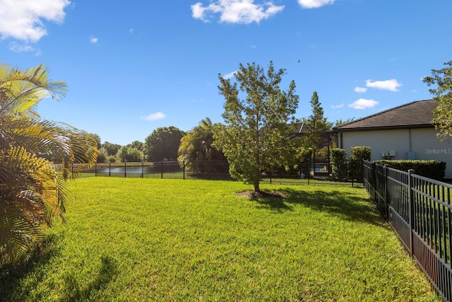 view of yard featuring a water view and fence