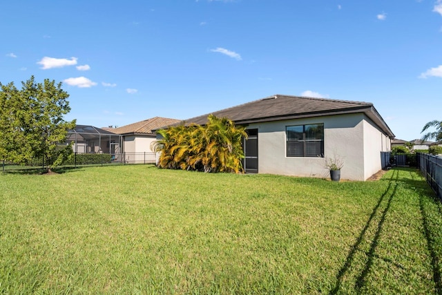 back of property featuring a fenced backyard, a lawn, and stucco siding