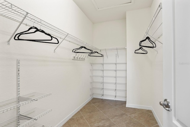 walk in closet with light tile patterned floors