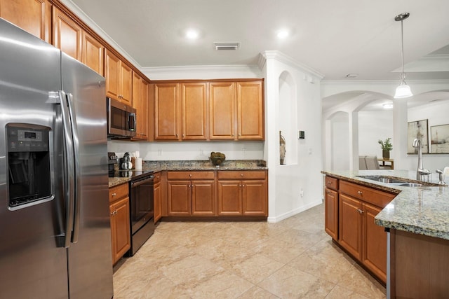 kitchen with stainless steel appliances, visible vents, brown cabinetry, a sink, and dark stone countertops