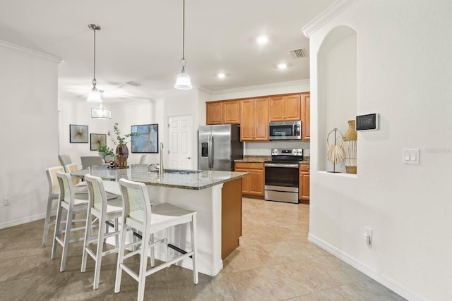 kitchen with a breakfast bar, crown molding, stainless steel appliances, a sink, and light stone countertops