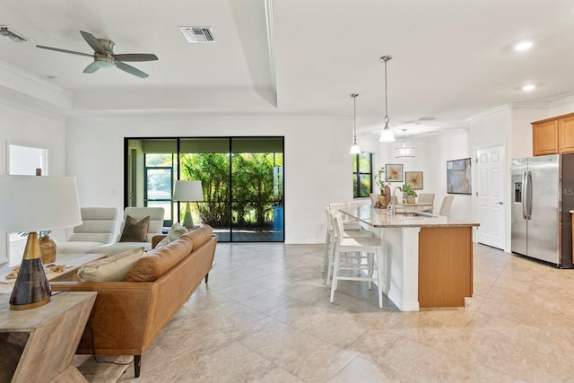 kitchen with light stone counters, visible vents, crown molding, and stainless steel fridge with ice dispenser