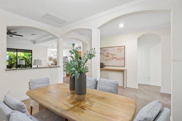 dining space featuring ornamental molding, arched walkways, baseboards, and a ceiling fan