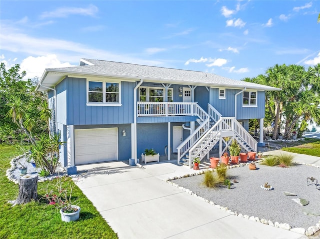 691 Gulf Bay Rd, Longboat Key, FL 34228 - beach home featuring a garage, a porch, stairs, and concrete driveway