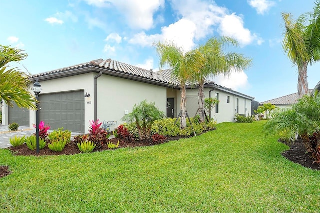 view of property exterior with a garage, a tile roof, a yard, driveway, and stucco siding