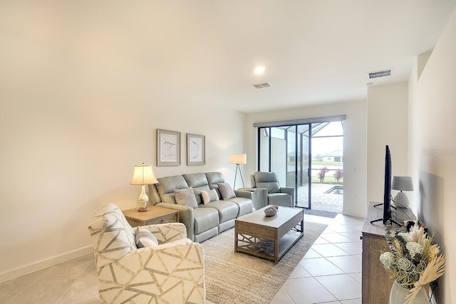 living area with baseboards, visible vents, and light tile patterned flooring