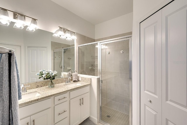 full bath featuring double vanity, a shower stall, and a sink